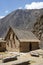 Stone building woth a reed roof at The Ollantaytambo Sanctuary, historical Inca site.