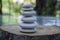 Stone cairn on green blurry background, light pebbles and stones