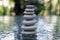 Stone cairn on green blurry background, light pebbles and stones