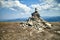 Stone cairn on mountain against blue sky with clouds