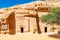 Stone carved nabataean tombs with tree ot the right, Jabal al banat, Hegra, Al Ula, Saudi Arabia