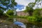 The stone castle wall is embedded into the green foliage close to a pond at Suomenlinna, Finland