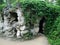 Stone cave overgrown with wattle grapes in the park