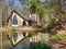 Stone chapel with stain glass window reflecting in the water of the lake lake