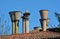 Stone chimneys on a terracotta roof rise against a blue sky