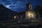 A stone church under a moonlit night sky, surrounded by nature, exudes a serene and mystical ambiance