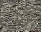 Stone cladding wall made of striped stacked slabs of natural gray rocks