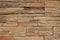 Stone cladding wall for rustic exterior, made of stacked natural brown rocks with irregular shapes