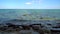 Stone coast and sea view. Sea horizon and blue sky in the distance. Waves crash on rocks on the ocean shore. Sea bay and