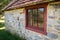 Stone Colonial building exterior with red six-pane window