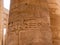 Stone column with Egyptian hieroglyphs, ancient drawings and symbols in the Karnak Temple. Close-up. Luxor, Egypt