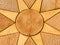 Stone compass rose set within a stone star. Golden coloured paving sla