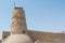 Stone cream colour ancient arabian fort with tower and high walls