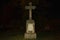 A stone cross glowing in the dark.