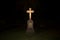 A stone cross glowing in the dark.