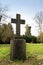 Stone cross in an old park or gravestone in a cemetery, memorial