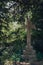 Stone cross on a tomb against greenery inside Hampstead Cemetery, London, UK