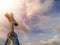 Stone cross on a top of a church, dramatic cloudy sky in the background. Catholic religion symbol