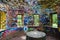 A stone cylinder shaped building in the forest covered with colorful graffiti surrounded by lush green trees at Lullwater Preserve