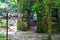 A stone cylinder shaped building in the forest covered with colorful graffiti surrounded by lush green trees at Lullwater Preserve