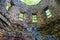 A stone cylinder shaped building in the forest covered with colorful graffiti surrounded by lush green trees at Lullwater Preserve