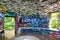 A stone cylinder shaped building in the forest covered with colorful graffiti surrounded by lush green trees at Lullwater Preserve