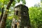 A stone cylinder shaped building in the forest covered with colorful graffiti surrounded by lush green trees at Lullwater Preserve