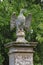 A stone eagle on a square plinth stands guard over an English country house