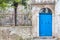 Stone facade with a blue entrance door of an old house in Rovinj