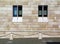 stone facade detail with narrow vertical glass windows with stone frame