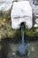 Stone face fountain in detail, water movement