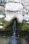 Stone face fountain with water in detail