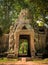 Stone face tower over the outer entrance gate of Ta Prohm temple, located in Angkor Wat complex near Siem Reap, Cambodia.