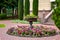 Stone flower bed fountain in the backyard with blooming petunias.