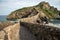 Stone footpath to famous landmark and film location in North of Spain, ocean islet with chapel San juan de gaztelugatxe, Basque