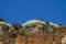 Stone fortress on a rock against the sky. Stone fence on the mountain