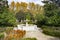 Stone fountain with trees and autumn vegetation around it. Next to the Royal Palace of Madrid, in Spain. Europe.