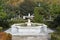 Stone fountain with trees and autumn vegetation around it. Next to the Royal Palace of Madrid, in Spain. Europe.