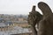 Stone gargoyle overlooking Paris from the Notre Dame