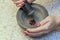 Stone Grinder Bowl. Woman Hands Grinding Pepper In Stone Mortar.