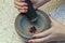 Stone Grinder Bowl. Woman Hands Grinding Pepper In Stone Mortar.