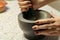 Stone Grinder Bowl. Woman Hands Grinding Pepper In Stone Mortar.