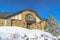 Stone home with small balcony over front door decorated with wreath in winter