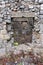 Stone house ruins window opening with plants growing inside