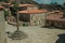 Stone houses and chapel encircling a square with pillory