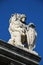 Stone lion with shield against blue sky