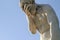 Stone male statue with a blue sky in the background