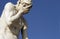 Stone male statue with a blue sky in the background