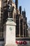 Stone memorial with bronze statue for Northumberland Fusiliers by old church with poppy wreaths laid in rememberance