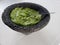 stone molcajete with guacamole sauce on the white table